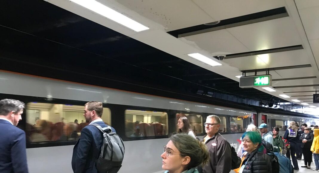 Passengers wait to board an arriving train in London.