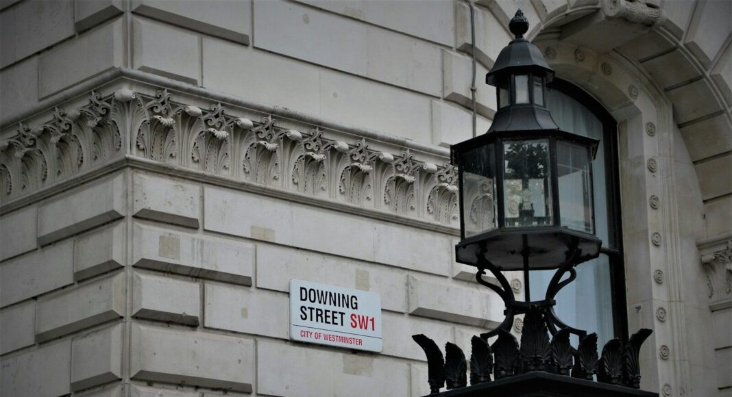 A Downing Street sign on a wall.