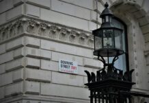 Public contracts to favour firms that deliver jobs and apprenticeships A Downing Street sign on a wall.