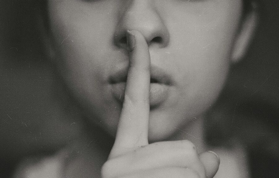 A woman holding her finger to her lips.