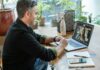 Is working from home really a career killer? A man working on a laptop in a home setting.