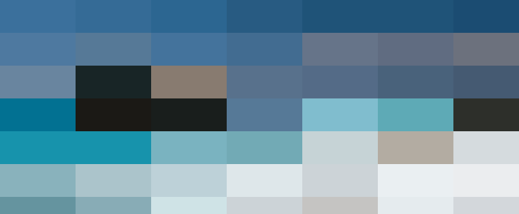 Turquoise sea with white foam, large rocks in the water, clear sky and distant mountains, viewed from a sandy beach managed by the HR department.