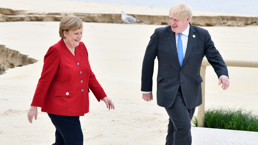 Two individuals walk together on a sandy terrain with a seagull in the background. The person on the left wears a red blazer, and the person on the right wears a suit and blue tie, subtly highlighting their income disparity.