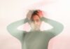 Chronic stress becoming ‘normalised’ at work, psychiatrist warns A blurred image of a woman with her hands on her head, looking stressed.