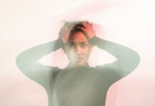 Chronic stress becoming ‘normalised’ at work, psychiatrist warns A blurred image of a woman with her hands on her head, looking stressed.