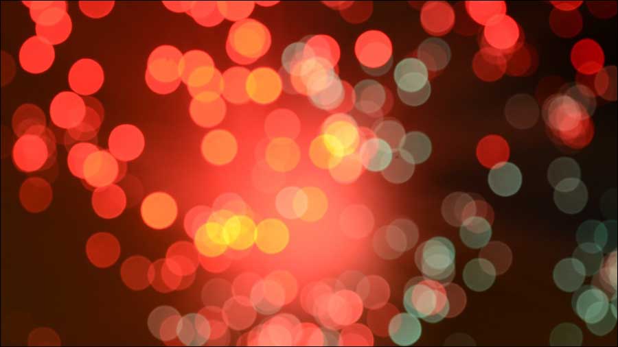 Image with a bokeh effect featuring out-of-focus circles of red, yellow, and green light on a dark background, reminiscent of the dynamic interplay in human resources where effective people management creates a vibrant yet cohesive team.
