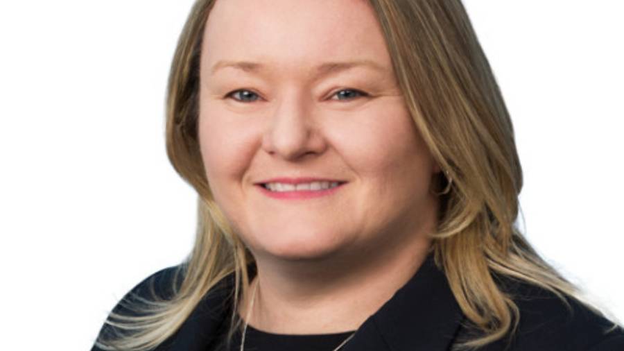 A woman with shoulder-length blonde hair is smiling, wearing a black blazer and a light-colored top, exuding professionalism as she embodies expertise in Human Resources.