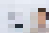 A woman examining a clock next to a wall.