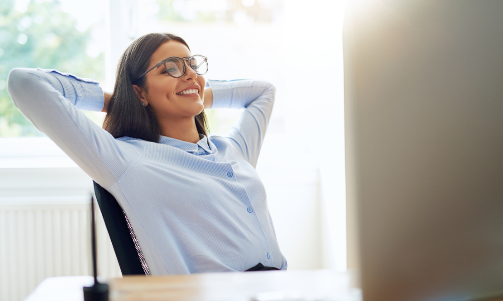 South East Asian woman leaning back in office chair, smiling