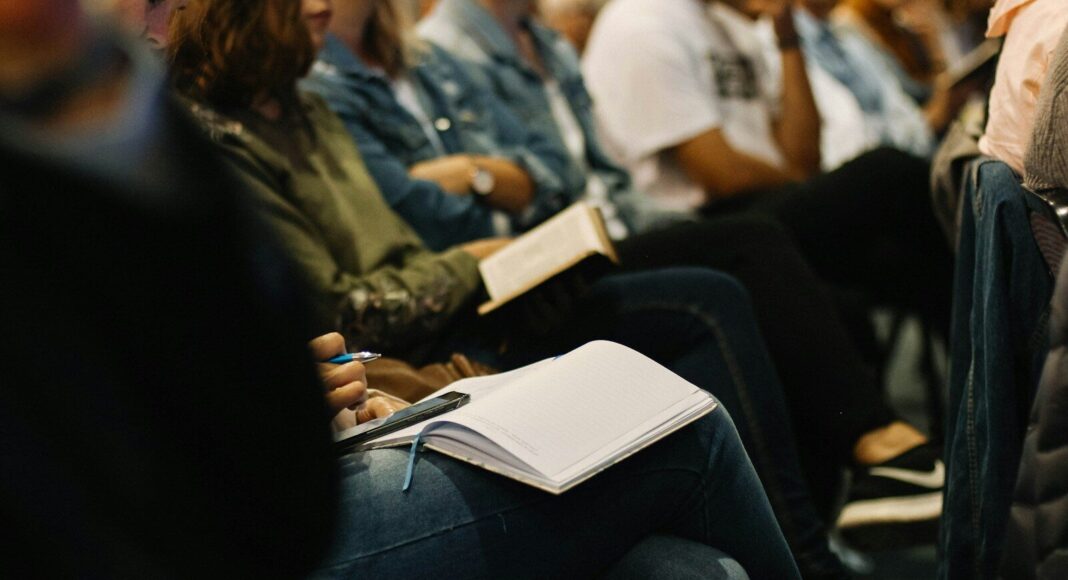 People taking part in a training session, seated and with books open on their laps.