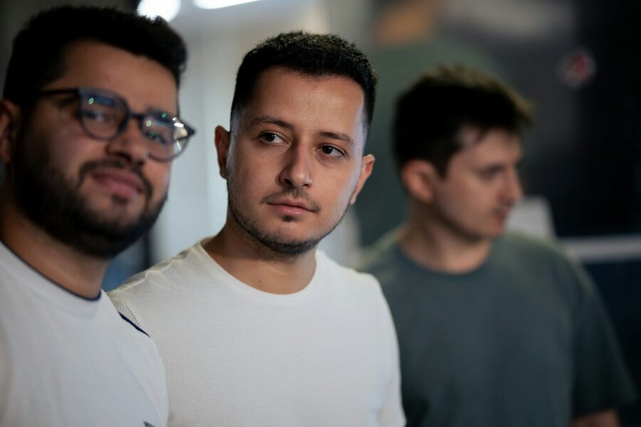 Three men standing next to each other.