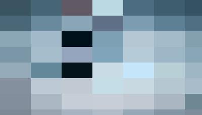 A person in a wheelchair on a paved street, focusing on the wheels and the person's lower body dressed in black, highlighting personnel mobility and accessibility.