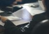 Up to 28,000 employees affected by paper-based data breaches A person reads paper documents at a desk.