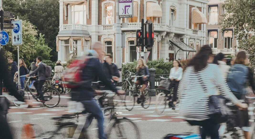 A blurred image of people cycling along a street.