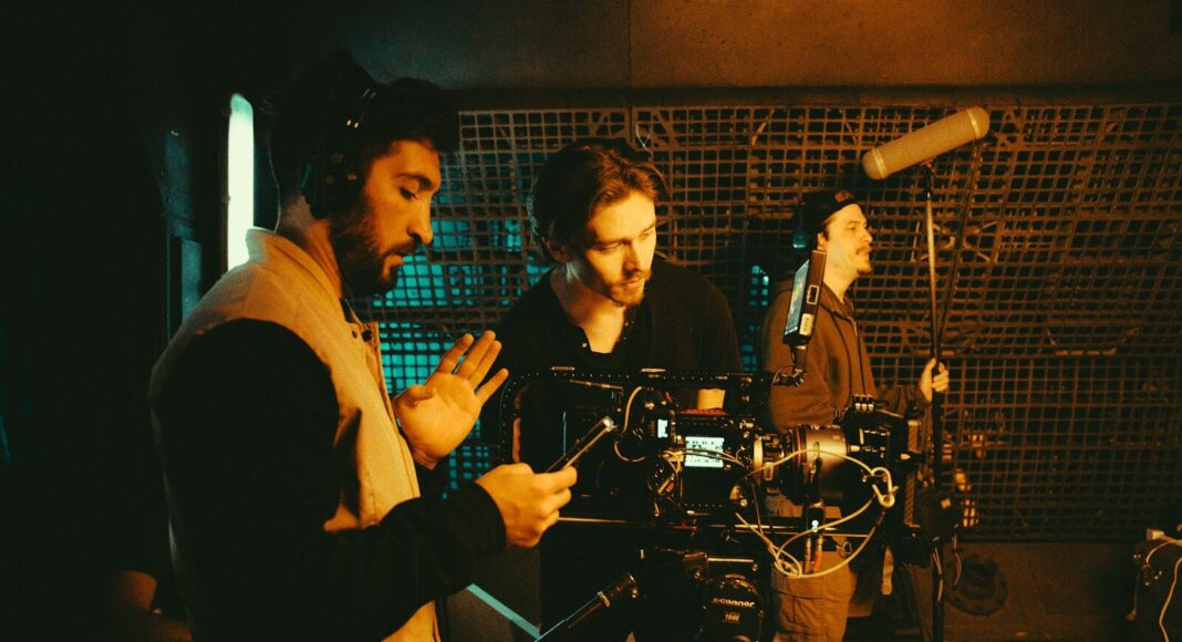 Film crew working with a camera and microphones.