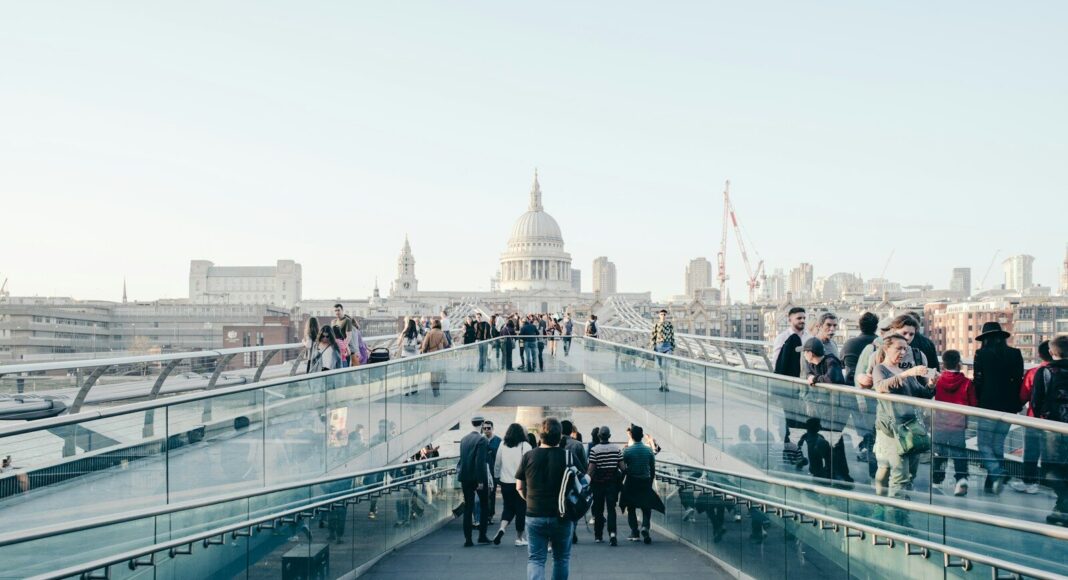 People walking across a bridge in London.