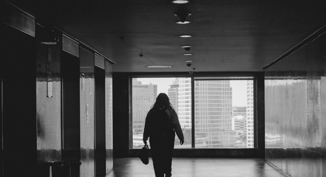 A person walking down a hallway in a building.