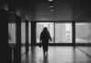 Return to the office ‘has not rebuilt workplace connections’ A person walking down a hallway in a building.