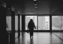Return to the office ‘has not rebuilt workplace connections’ A person walking down a hallway in a building.