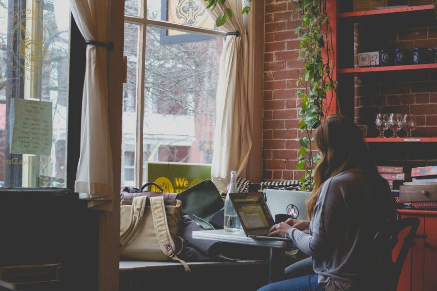 A woman works on a computer in a cafe.