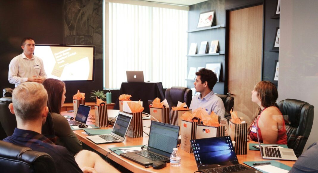 Office workers around a table at a meeting.