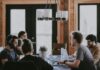Workplace belonging ‘rises to highest level in a decade’, but many workers still feel excluded People sit around a table in an office, having a meeting.