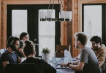 Workplace belonging ‘rises to highest level in a decade’, but many workers still feel excluded People sit around a table in an office, having a meeting.