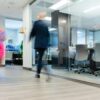 A blurry photo of a man and a woman walking in an office.