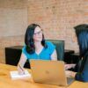 Two women having a performance review meeting at a table.
