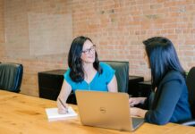 Performance reviews leave many workers feeling ‘less positive’ Two women having a performance review meeting at a table.