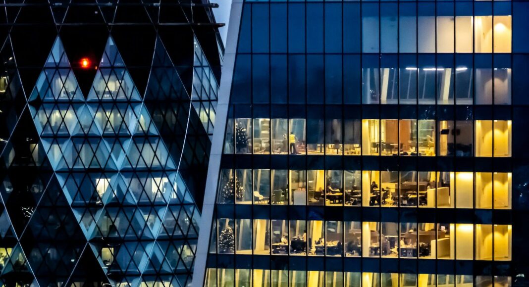 Photo by Nick Fewings Offices with lights on at night.