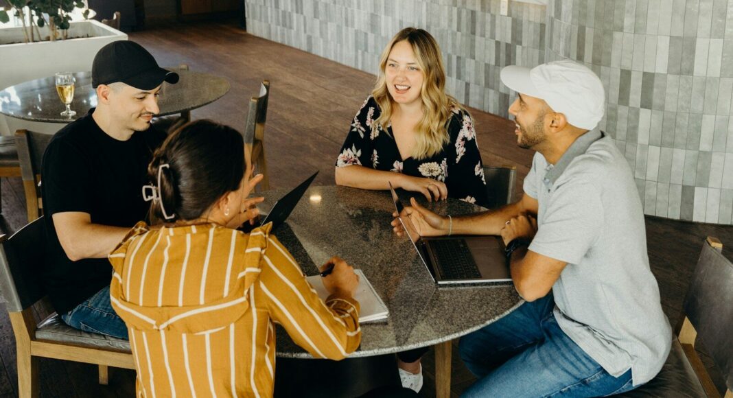 A group of young people working with laptops at a table.