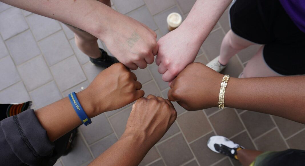 A group of people putting their hands together.