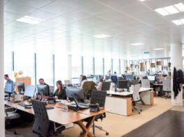 Most organisations lack a strategy to communicate workplace change: report Staff working at desks in an open-plan office.