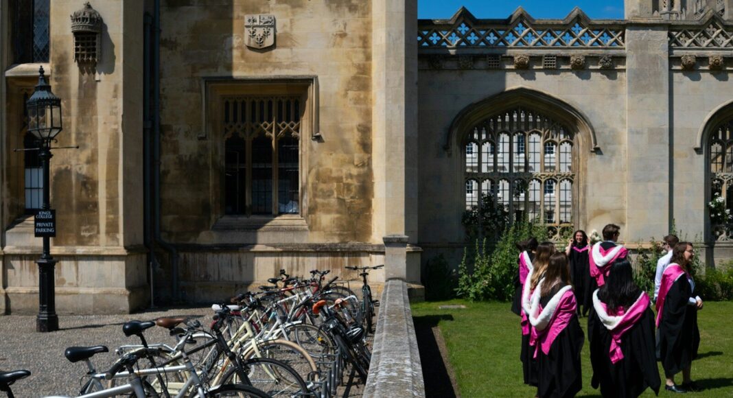 Students walk in gowns on campus.