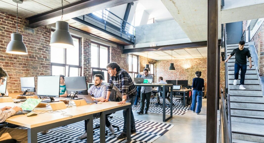 People working at desks in an open-plan office.