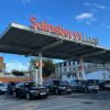 Cars parked under a Sainsbury's supermarket sign.