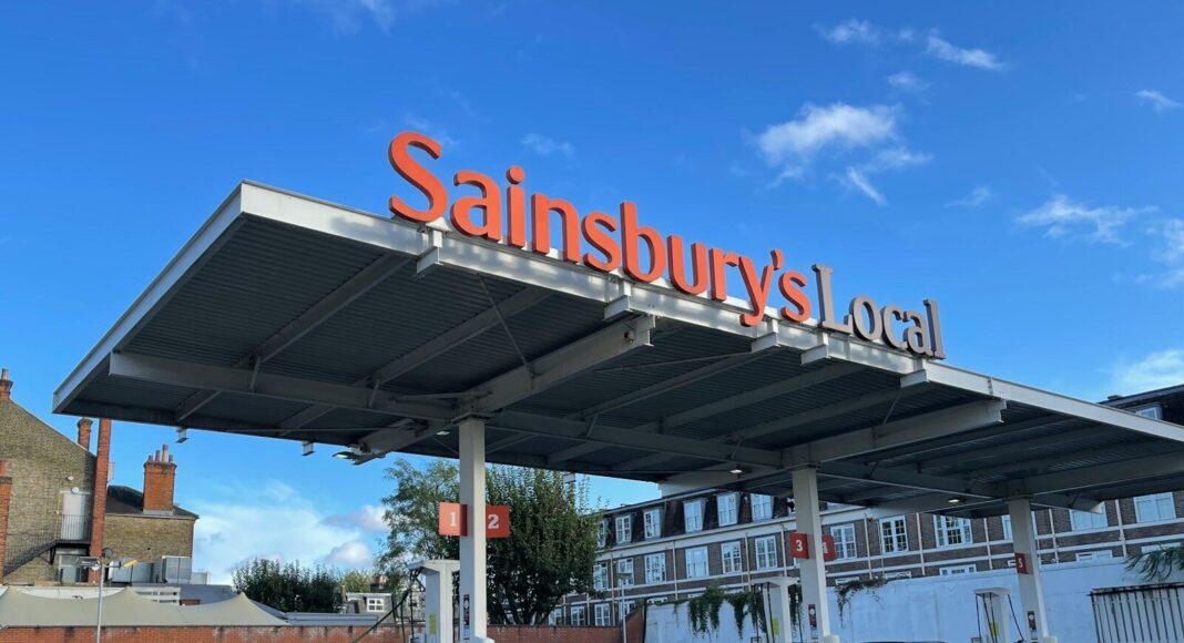 Cars parked under a Sainsbury's supermarket sign.