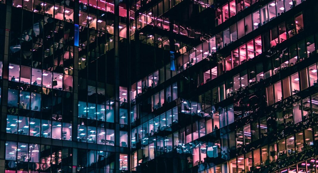 Office buildings lit up at night.