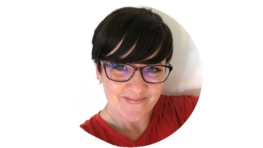 Person with short dark hair and glasses, wearing a red top, smiling at the camera, representing our HR Personnel.