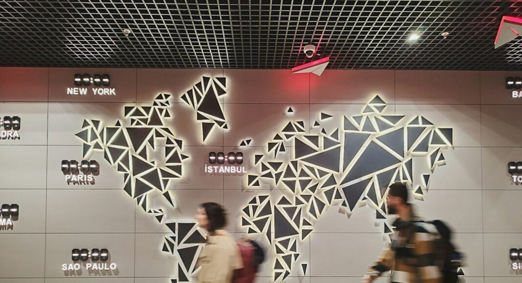 People walk past a glowing world map.