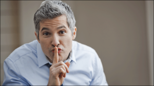 Man holds finger to mouth - silence!