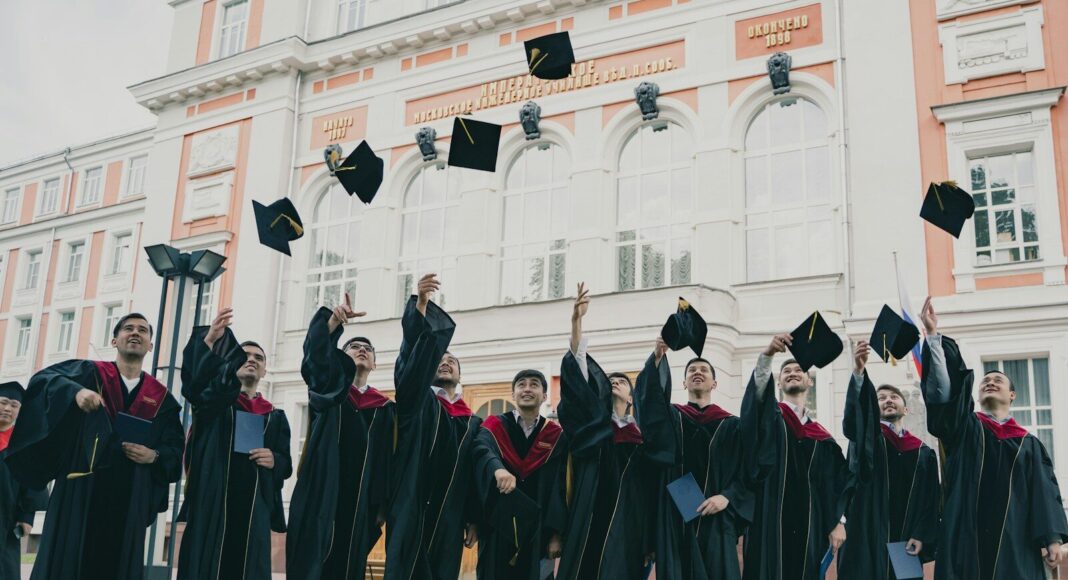 A group of graduates throwing their caps up.