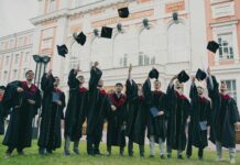 Graduate job pathway weakens as young workers move into trades A group of graduates throwing their caps up.