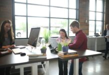 More employees use workplace health benefits, but barriers still limit access People working on an open-plan office,
