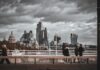 UK set for biggest rise in unemployment among G7 nations, OECD warns People walking across a bridge in London with a grey, stormy sky in the background.