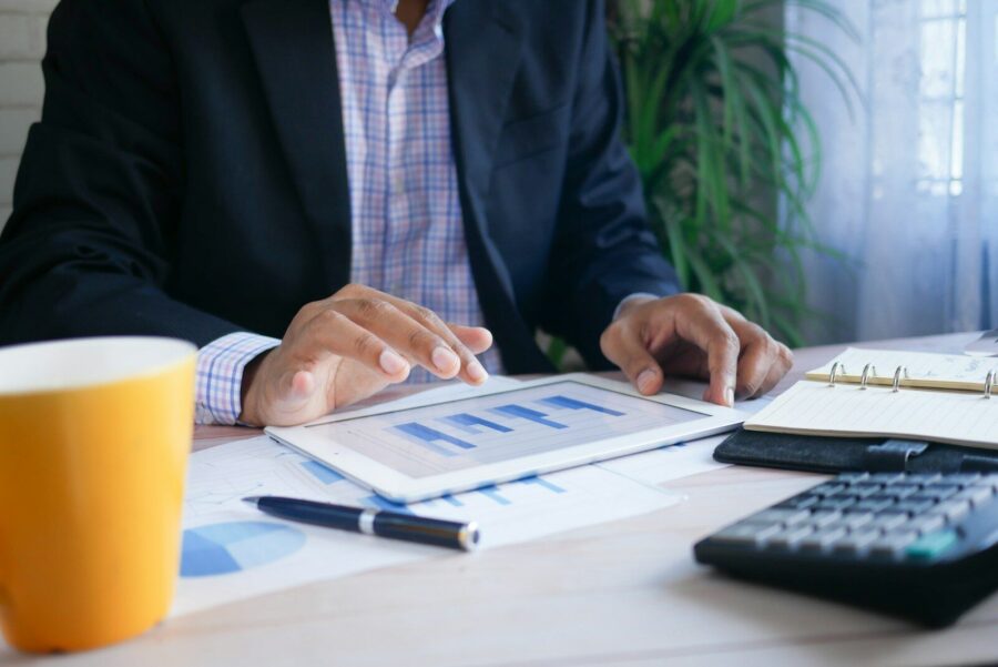 A man working on finances using figures and a calculator.