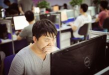 Cost-of-living pressures ‘keep unhappy workers in their jobs’ Man working at a computer in an office.