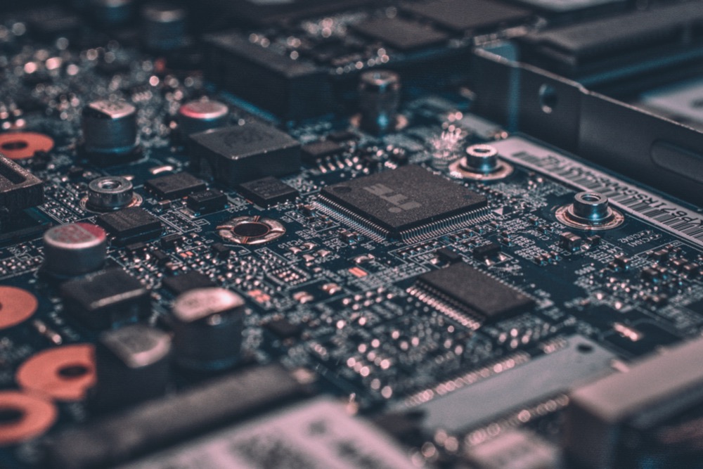 A close-up view of an electronic circuit board showing various components including resistors, capacitors, and integrated circuits highlights the skills gap in modern electronics.