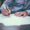 A man writing on paper.